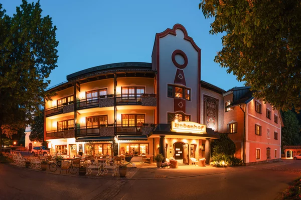 Bike Hotel Illuminated hotel building with balconies and outdoor seating area at dusk