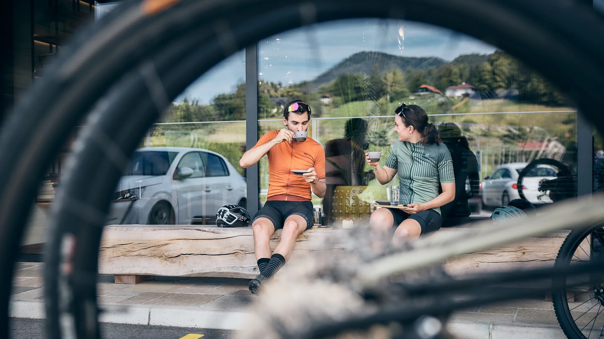 MTS Austria © Tobias Köhler Two cyclists drinking coffee on bench, bike tire in foreground