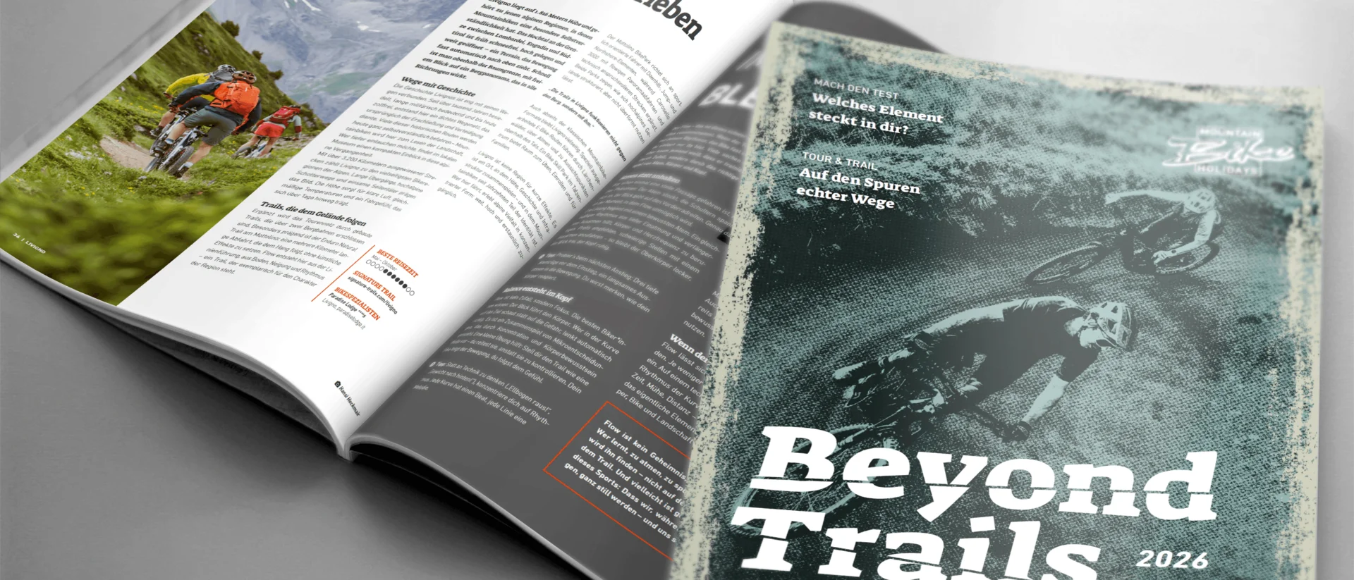 Open magazine displaying mountain bike trail and alpine scenery