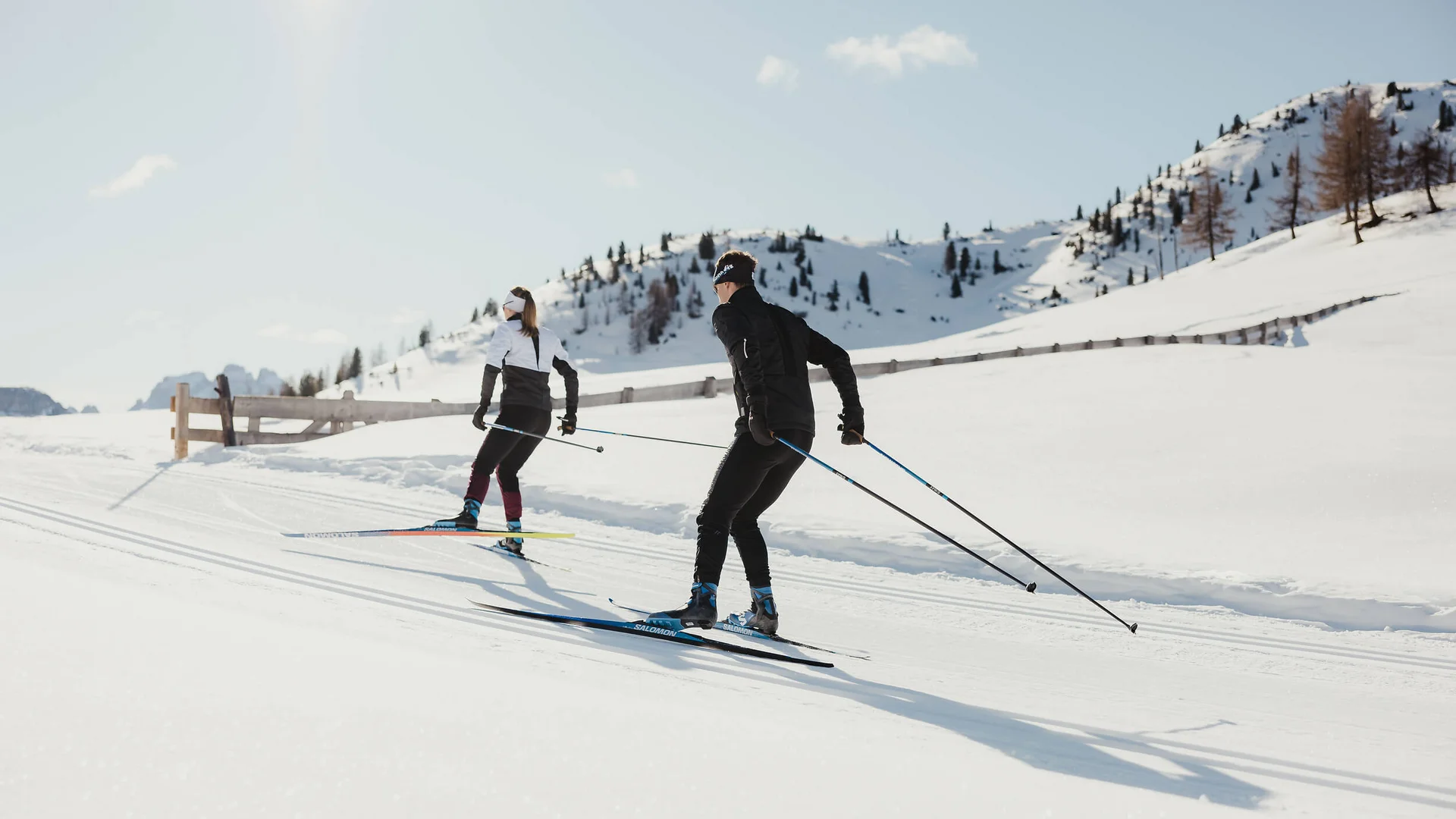 Destination development © Alex Moling Two cross-country skiers on snowy mountains under bright sunlight