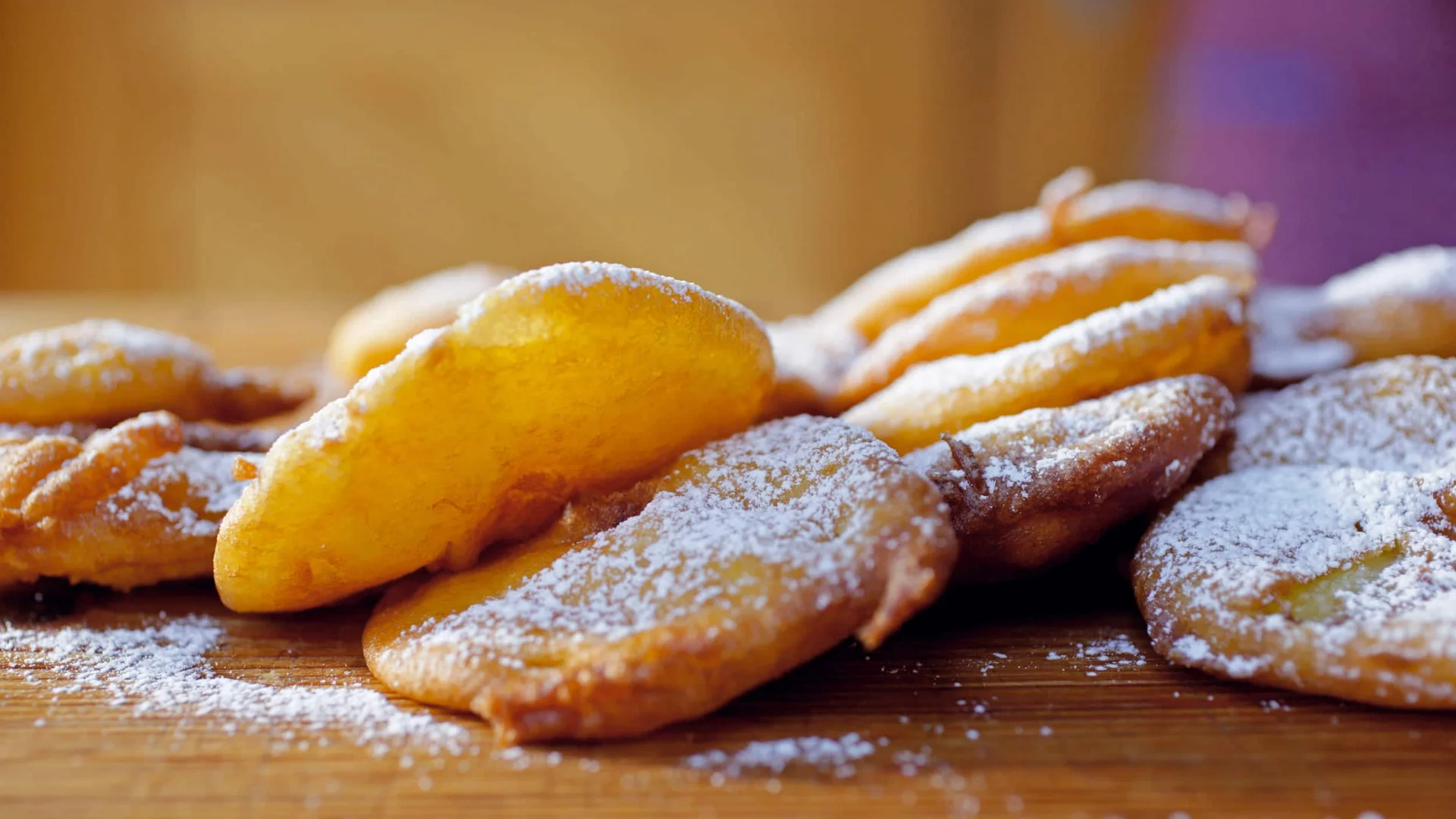 Velontour © IDM Südtirol - Frieder Blickle Fried sweet dough pieces dusted with powdered sugar on wooden board