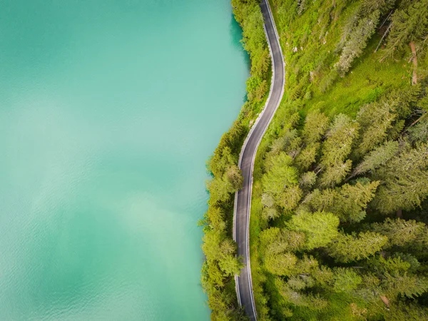 Velontour © Tourist Info Antholzertal - Plaickner Josef Aerial view of a winding road beside a green forest and turquoise lake