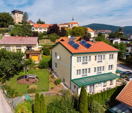Bed&Breakfast Mittelkärnten © Bed and Breakfast Mittelkärnten Dorf mit Häusern, Solarpanelen und Burgturm im Hintergrund bei klarem Himmel
