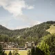 Hotel surrounded by forested hills and cloudy sky