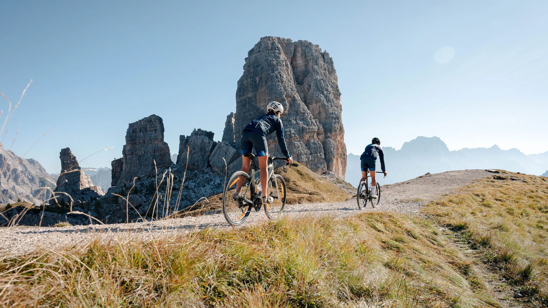 Bike Hotel © Josef Plaickner Two cyclists riding on mountain trail with large rock formation in sunny weather