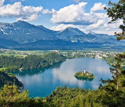 Julische Alpen © Jost Gantar - www.slovenia.info See mit Insel und Berglandschaft bei klarem Himmel