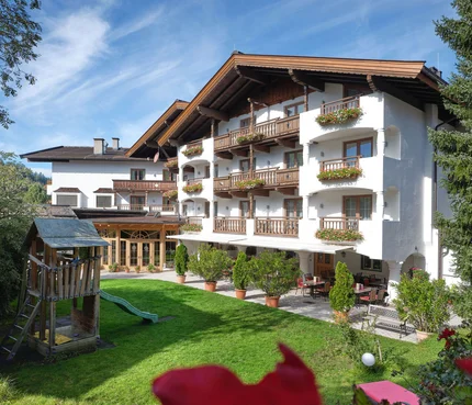 Hotel Metzgerwirt © Andreas Wimmer Hotelgebäude mit Balkonen und Spielplatz im Garten