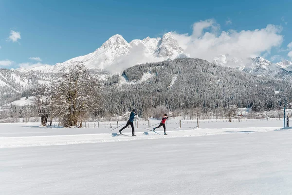 Cross-country skiing & ski touring hotel © Michael Geißler Two cross-country skiers in snowy landscape with mountains in background