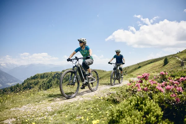 Bike Hotel © Tobias Köhler Two people riding e-mountain bikes on a mountain trail on a sunny day