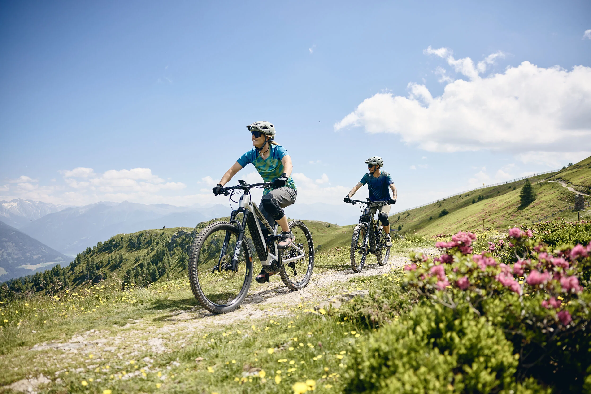 Bike Hotel © Tobias Köhler Two people riding e-mountain bikes on a mountain trail on a sunny day