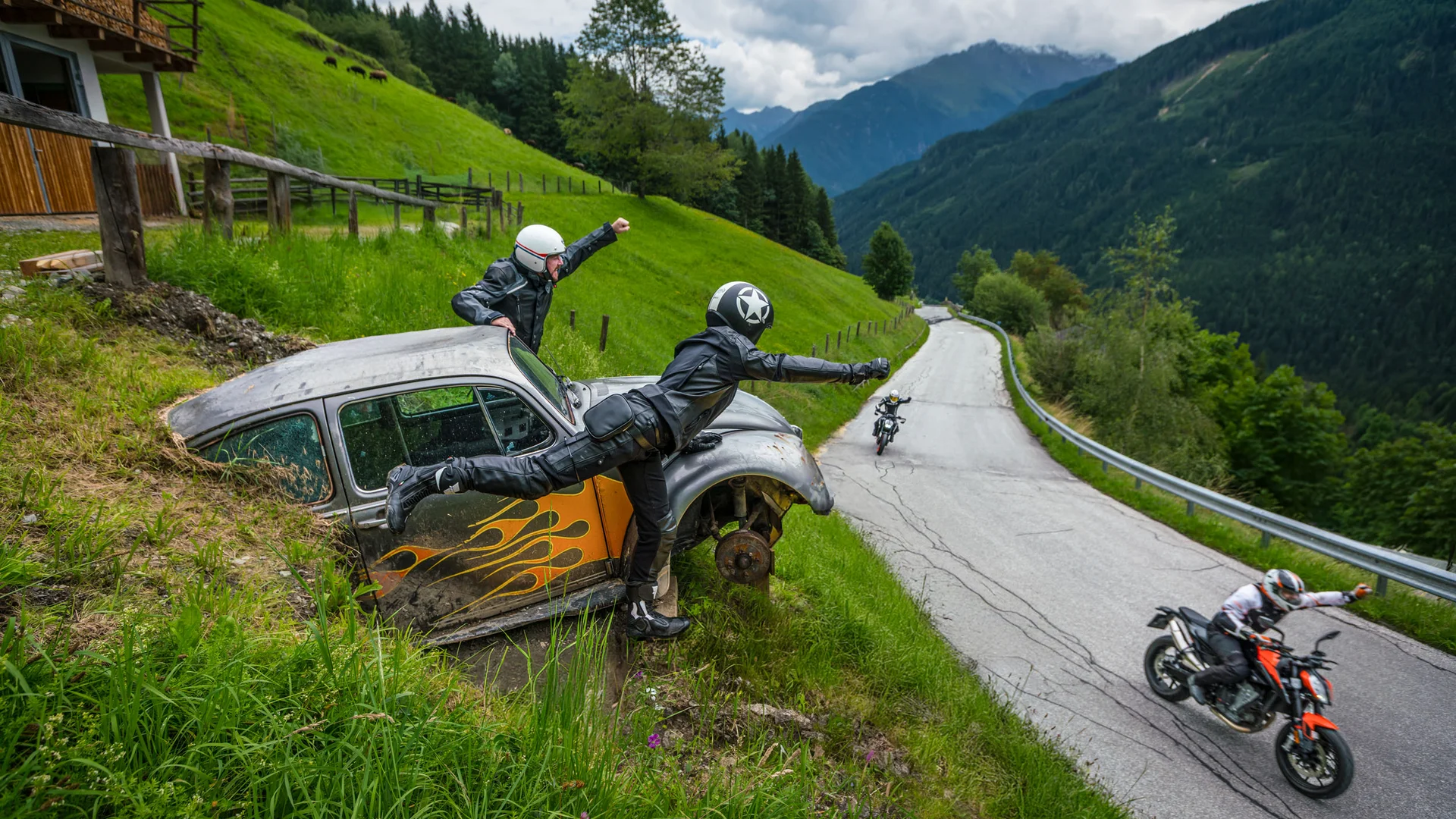 MoHo – Motorbike Hotels © Moppetfoto.de Motorcyclists waving from an old car by the roadside in the mountains