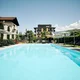 Outdoor swimming pool with loungers and umbrellas in front of a hotel building