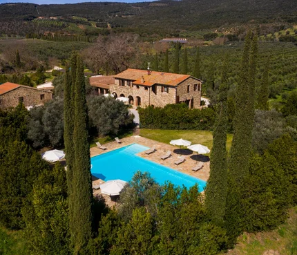 Tenuta Il Cicalino © Tenuta il Cicalino Steinhaus mit Pool umgeben von Bäumen in einer grünen Hügellandschaft