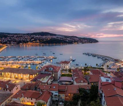 Istrien © www.slovenia.info - Jaka Ivancic Abendlicher Blick auf Hafen und Stadt mit beleuchteten Gebäuden am Wasser